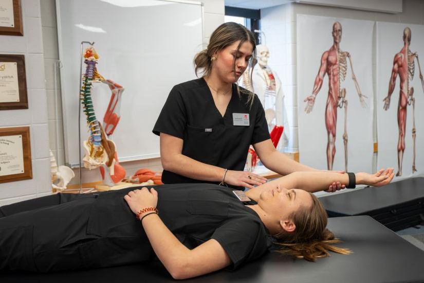 运动训练硕士 students gather for a demonstration during an athletic training class.